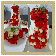 3 tier cake with coral adn white fresh roses cascading down the centre